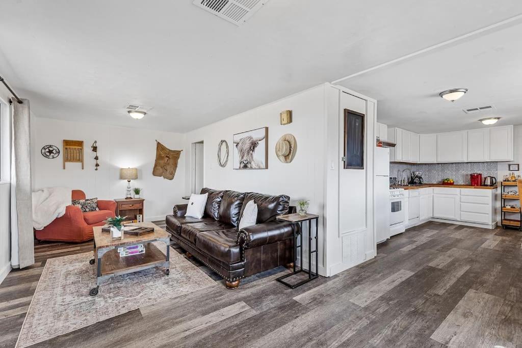 een woonkamer met een leren bank en een keuken bij Grand Canyon Ranch Home - Big city lot - Real Western History in Williams