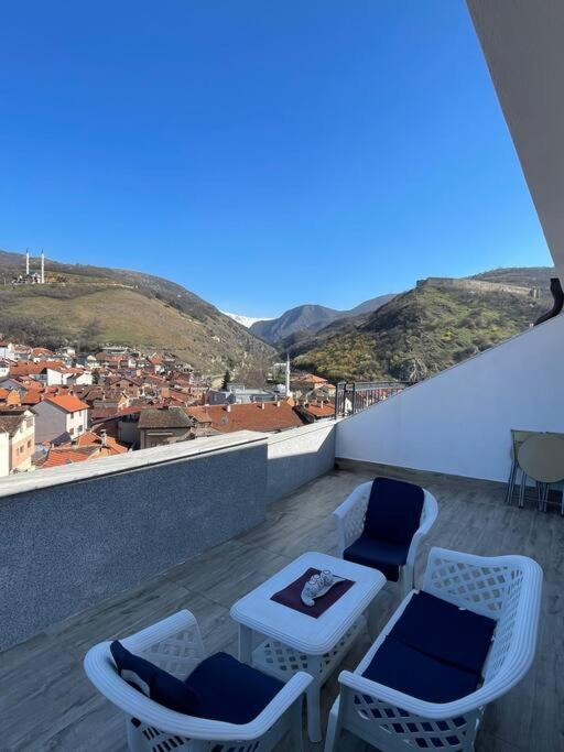 a balcony with chairs and a table and a view at Penthouse with castle view in Prizren