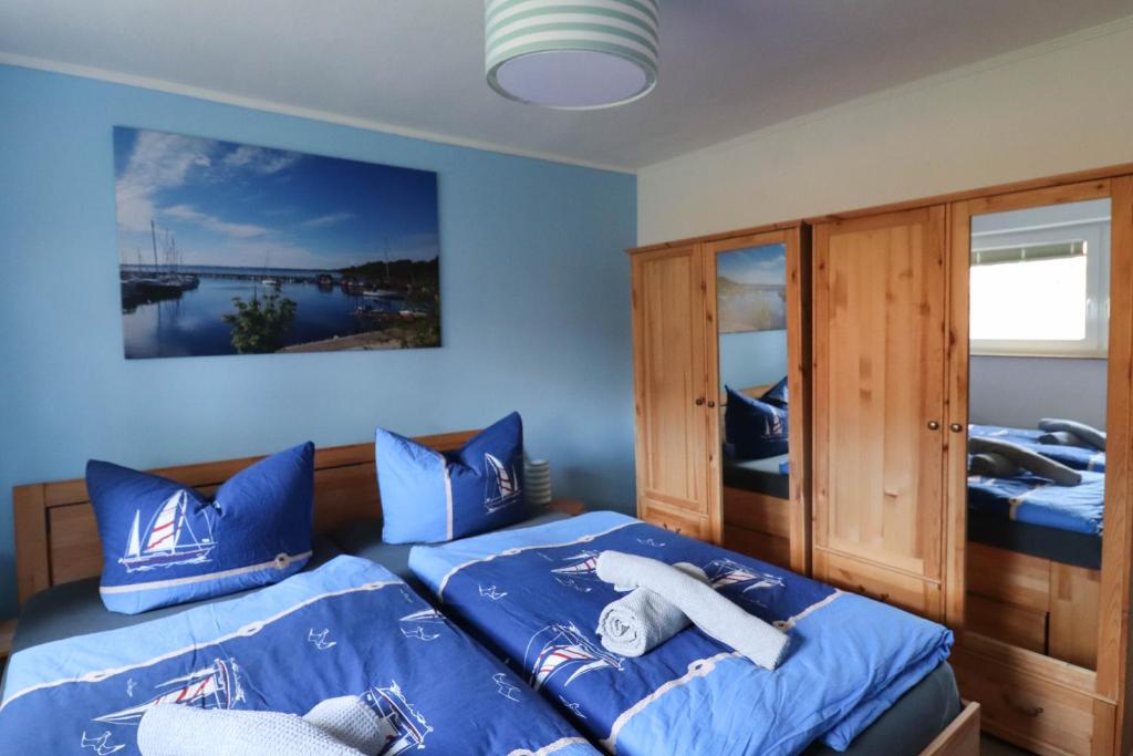 een slaapkamer met 2 bedden en blauwe kussens bij Dat Niehuus Tarnewitz in Boltenhagen