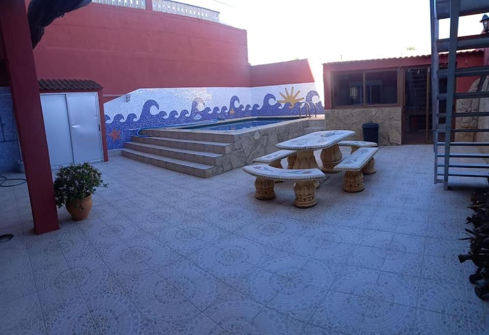 a patio with two picnic tables in front of a building at casa con piscina privada in Vinarós