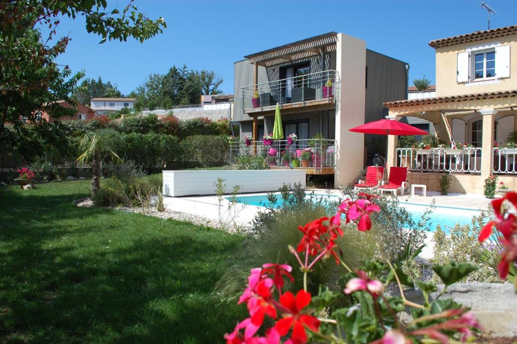 ein Haus mit einem Pool und einem Garten mit Blumen in der Unterkunft Gîte Le Logis Vallat haut in Fuveau