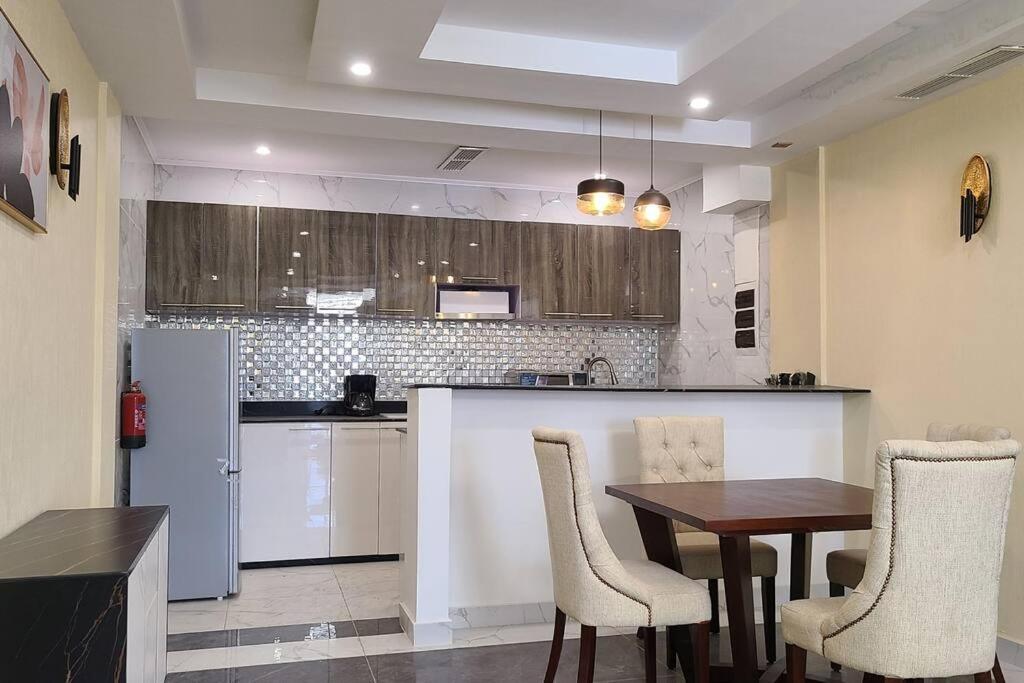 a kitchen with a table and chairs and a kitchen with a refrigerator at Luxurious Studios in Douala