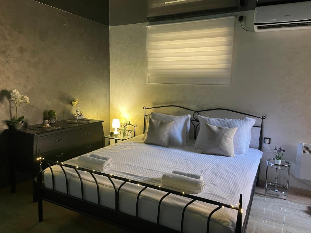 um quarto com uma cama com lençóis brancos e almofadas em Apartman Stefan Lux em Vrdnik