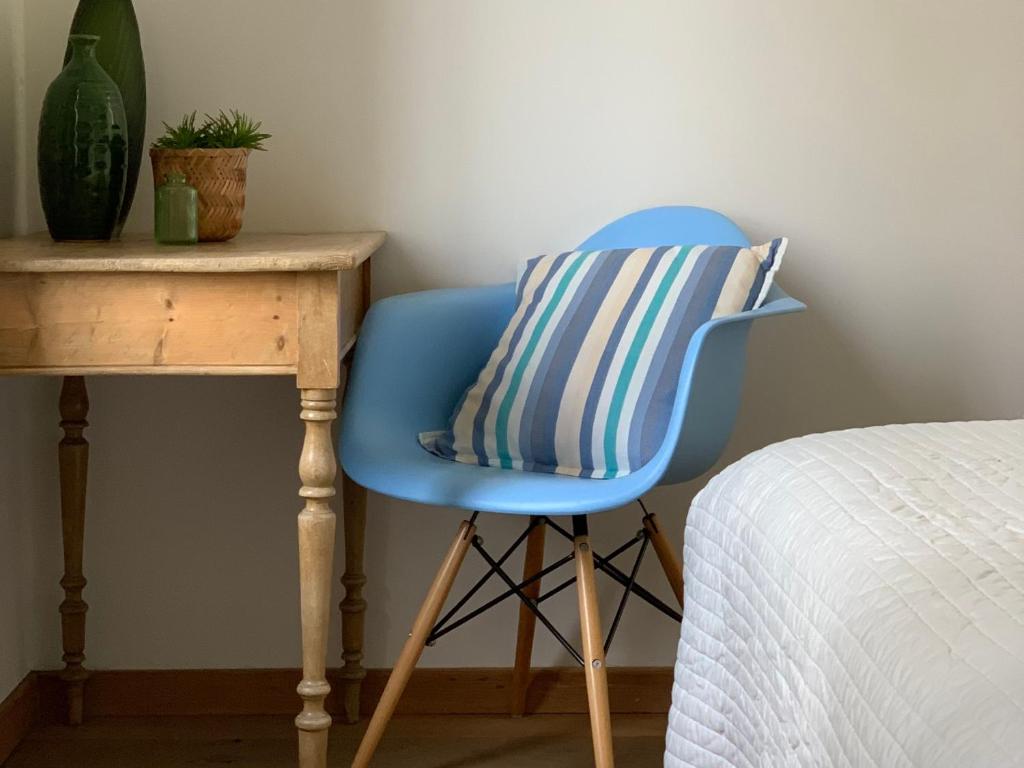 una sedia blu con un cuscino accanto a una scrivania di Hotel Au Nom De Dieu a Dilsen-Stokkem