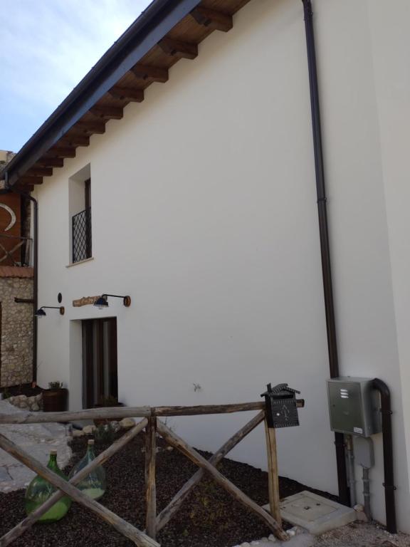 un bâtiment blanc avec une clôture devant lui dans l'établissement La Locanda n'gima all' ara, à Aielli