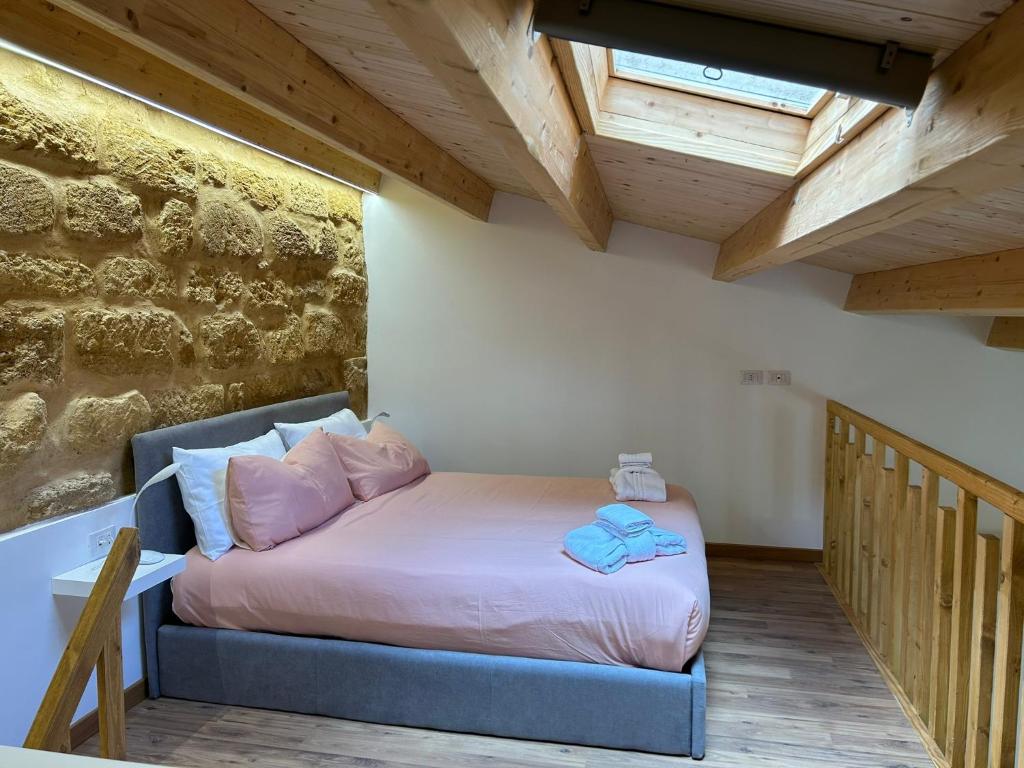 Un dormitorio con una cama en una habitación con techos de madera. en LA FORMICA APARTMENT, en Agrigento