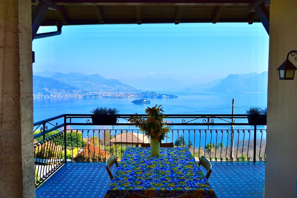 einen Tisch auf einem Balkon mit Blick auf das Wasser in der Unterkunft Il lago e la collina in Stresa