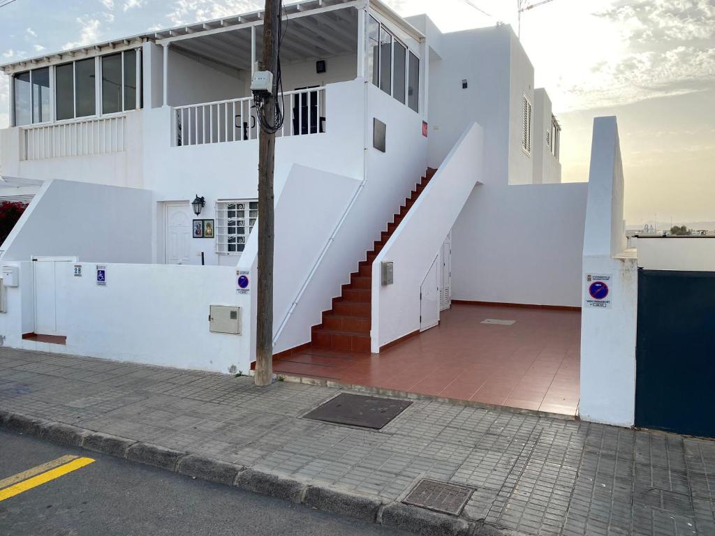 ein weißes Gebäude mit einer Seitentreppe in der Unterkunft Casa La Orilla 1 in Playa Honda