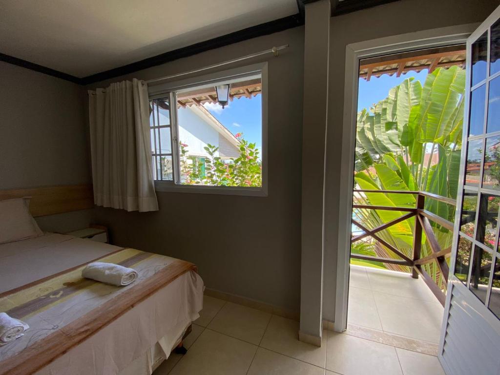 タマンダレーにあるPousada Pérola do Marのベッドルーム1室(ベッド1台、大きな窓付)