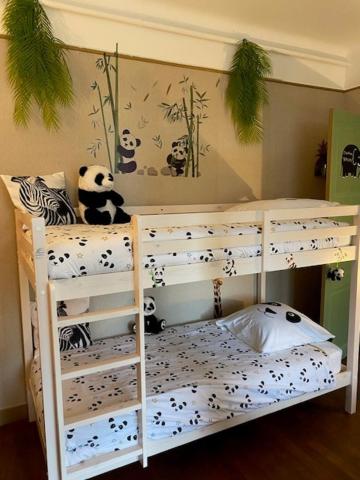 a panda bear sitting on top of a bunk bed at Le Moulin du Modon in Couffy
