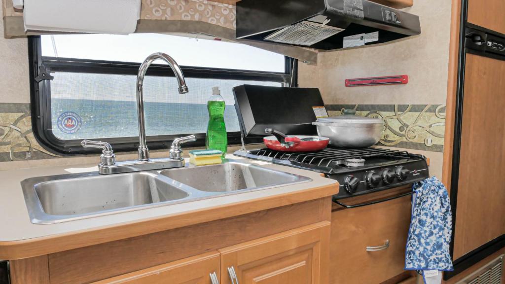 a kitchen with a sink and a stove with a window at Travel the Dominican Republic in campervan in Santo Domingo