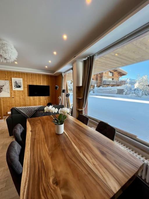 a living room with a wooden table and a large window at Megeve centre in Megève
