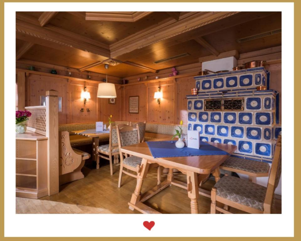 a dining room with tables and chairs and a refrigerator at Berghupferl - do legst di nieda in Oberaudorf