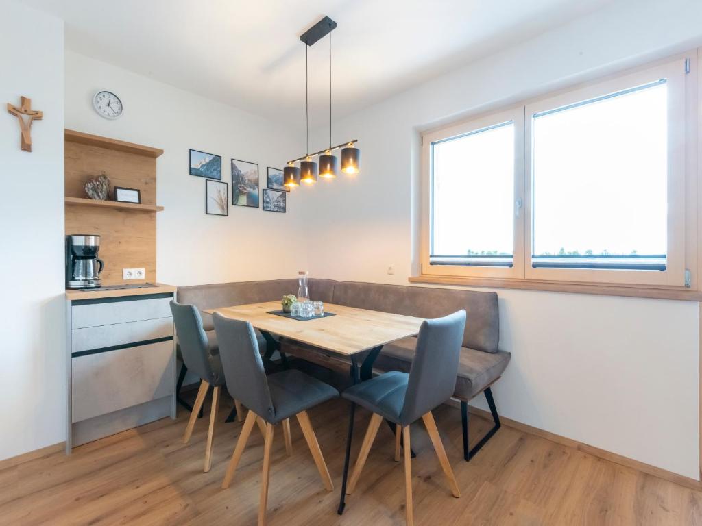a kitchen and dining room with a wooden table and chairs at Haus Heimat - Alpenrose 