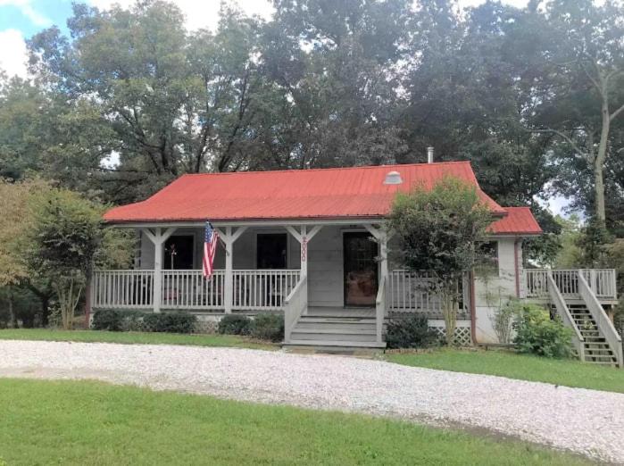 una pequeña casa con techo rojo y porche en Pigeon Ridge Cabin Cumberland State Park 2B 2B, en Crossville