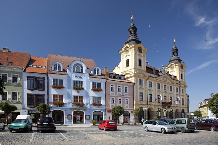 un gruppo di edifici con auto parcheggiate in un parcheggio di Hotel City Pisek a Písek