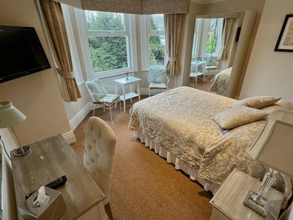 1 dormitorio con 1 cama, mesa y sillas en Cheshire Hospitality Ltd Trading As Lennox Lea Studios and Apartments en Sale