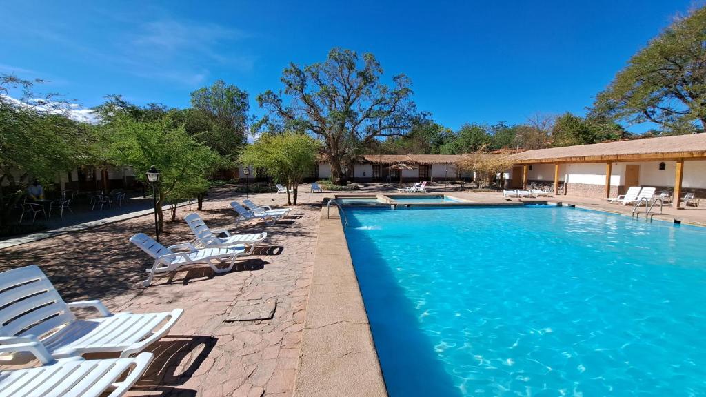 uma piscina com espreguiçadeiras e um resort em Hotel Diego de Almagro San Pedro De Atacama em San Pedro de Atacama