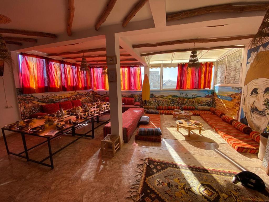 ein großes Wohnzimmer mit einem Sofa und einem Tisch in der Unterkunft Happy Surf Hostel in Taghazout