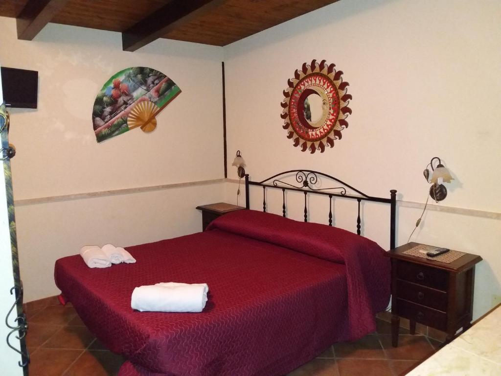 a bedroom with a red bed and a mirror at APPARTAMENTO A SAN VITO LO CAPO STANZA CON BAGNO in San Vito lo Capo