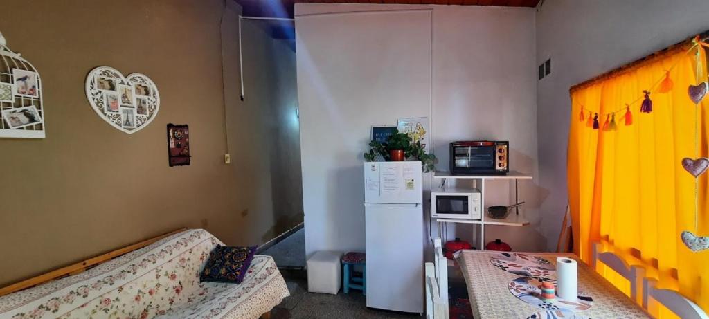eine Küche mit einem Kühlschrank und einem Sofa in einem Zimmer in der Unterkunft Descanso en la Patagonia in Trelew