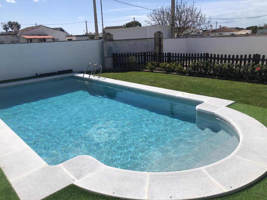 een zwembad in een tuin met een tuin bij Chalet Ventura en Conil in Conil de la Frontera