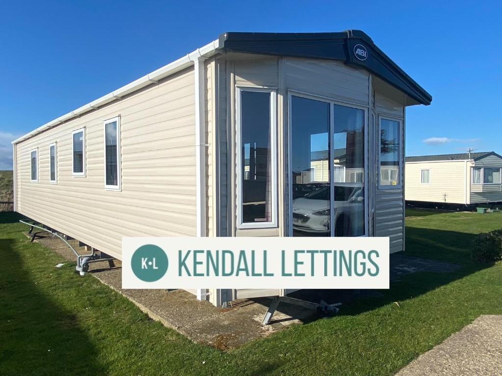 a tiny house with a sign that reads kennel settings at Abi in Selsey