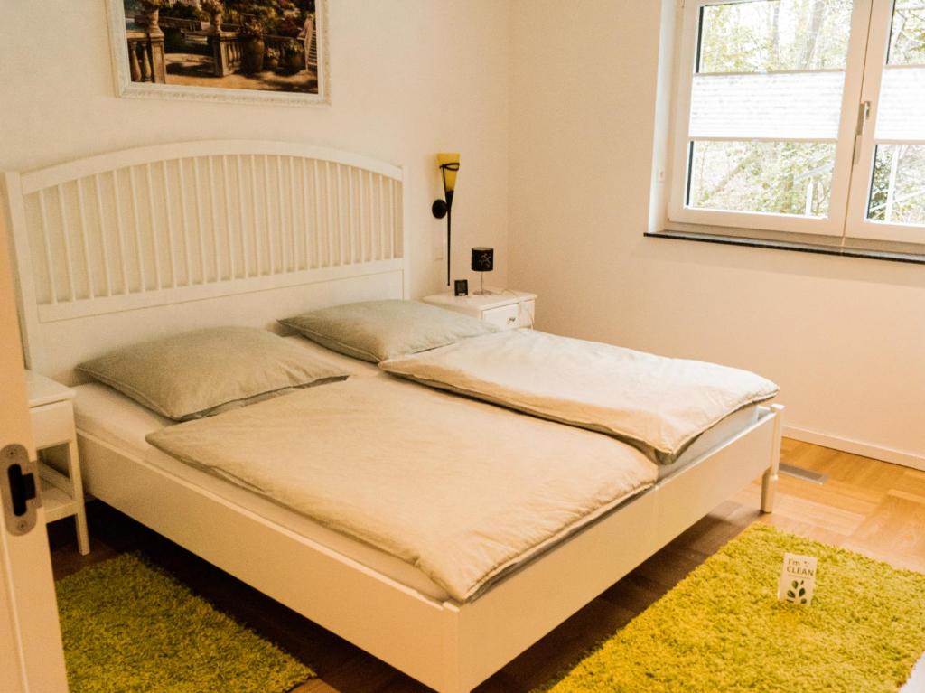 a white bed in a room with a window at FeWo-Seefunkeln in Diensdorf am Scharmützelsee in Diensdorf-Radlow