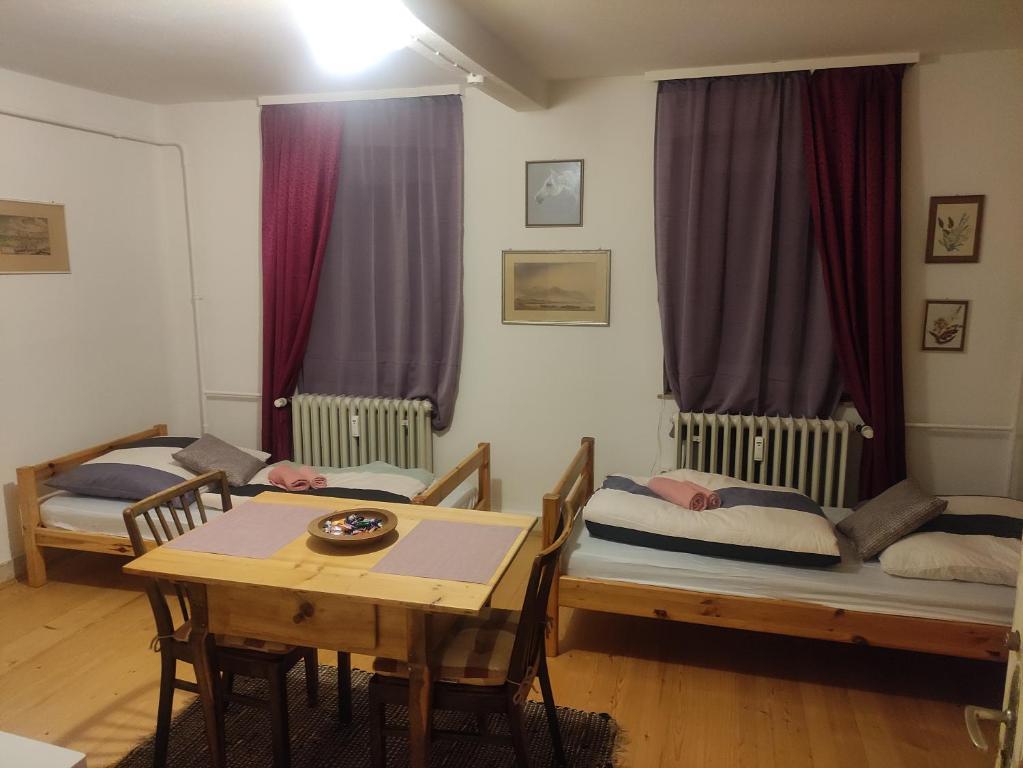 a room with two twin beds and a table at Zimmer A Veljanovski in Blaufelden