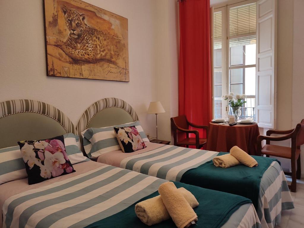 een slaapkamer met 2 bedden en handdoeken bij Principe B in Granada