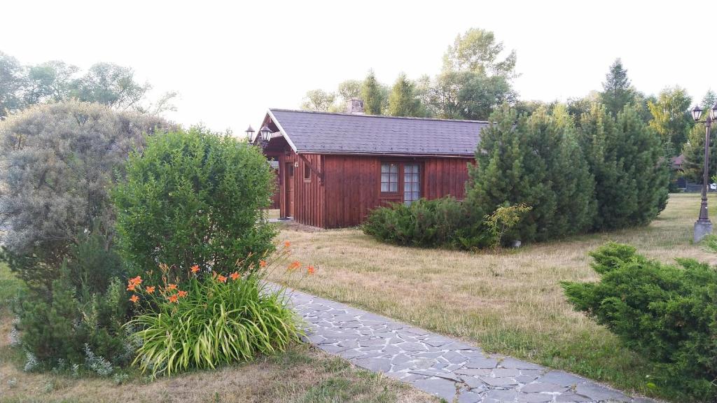 a small red house with a path in front of it at Chata 412 Tatralandia in Liptovský Mikuláš