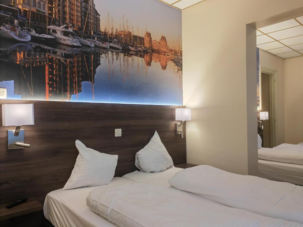 a hotel room with two beds and a painting on the wall at Hotel Albert II Oostende in Ostend