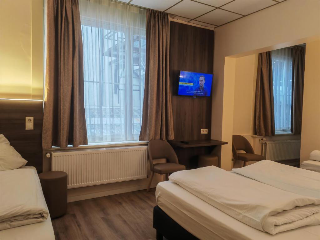 a hotel room with two beds and a window at Hotel Albert II Oostende in Ostend