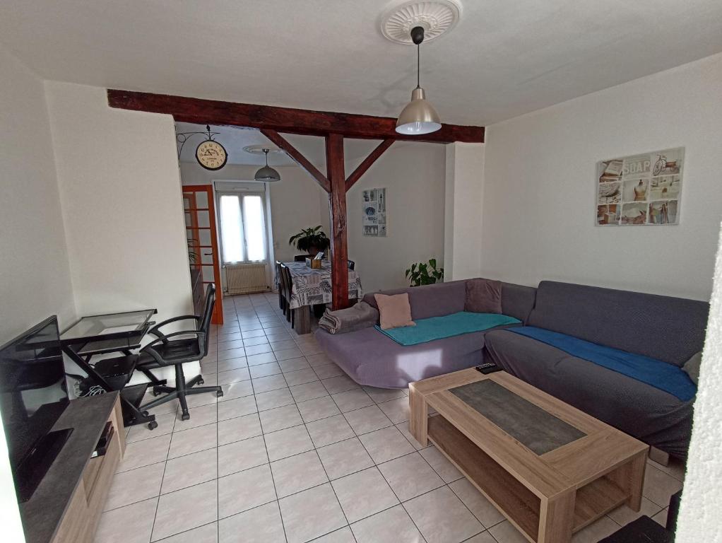 a living room with a couch and a table at Maison de ville de 95M2 in Montmorillon