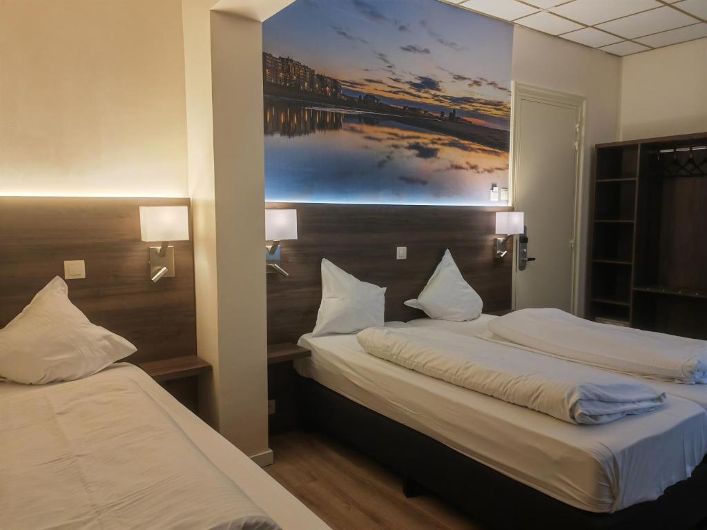 two beds in a hotel room with a painting on the wall at Hotel Albert II Oostende in Ostend