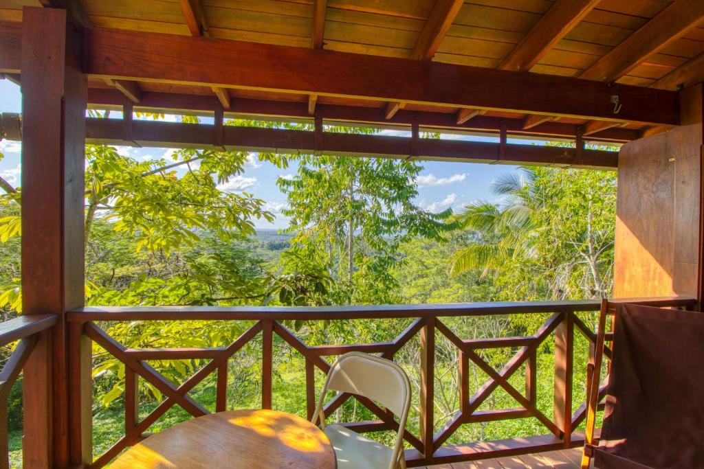 a room with a balcony with a table and chairs at Punta Studio at Framadani Estate in San Ignacio