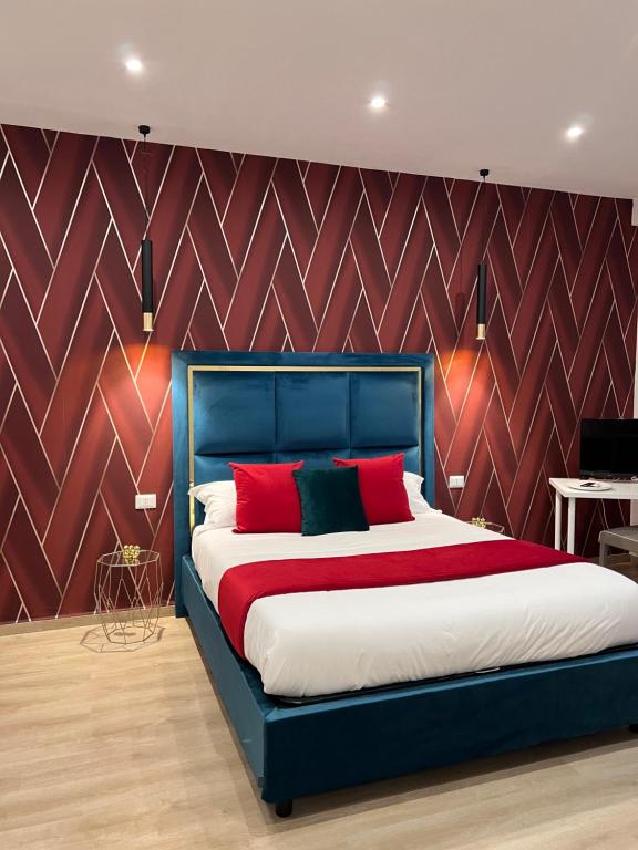 a bedroom with a blue bed with red pillows at Easy Boarding in Naples