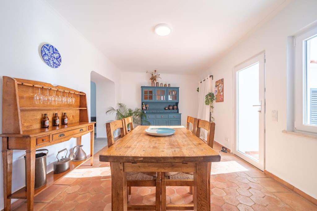 een eetkamer met een houten tafel en stoelen bij Peaceful, spacious & stylish, a real home! in Budens