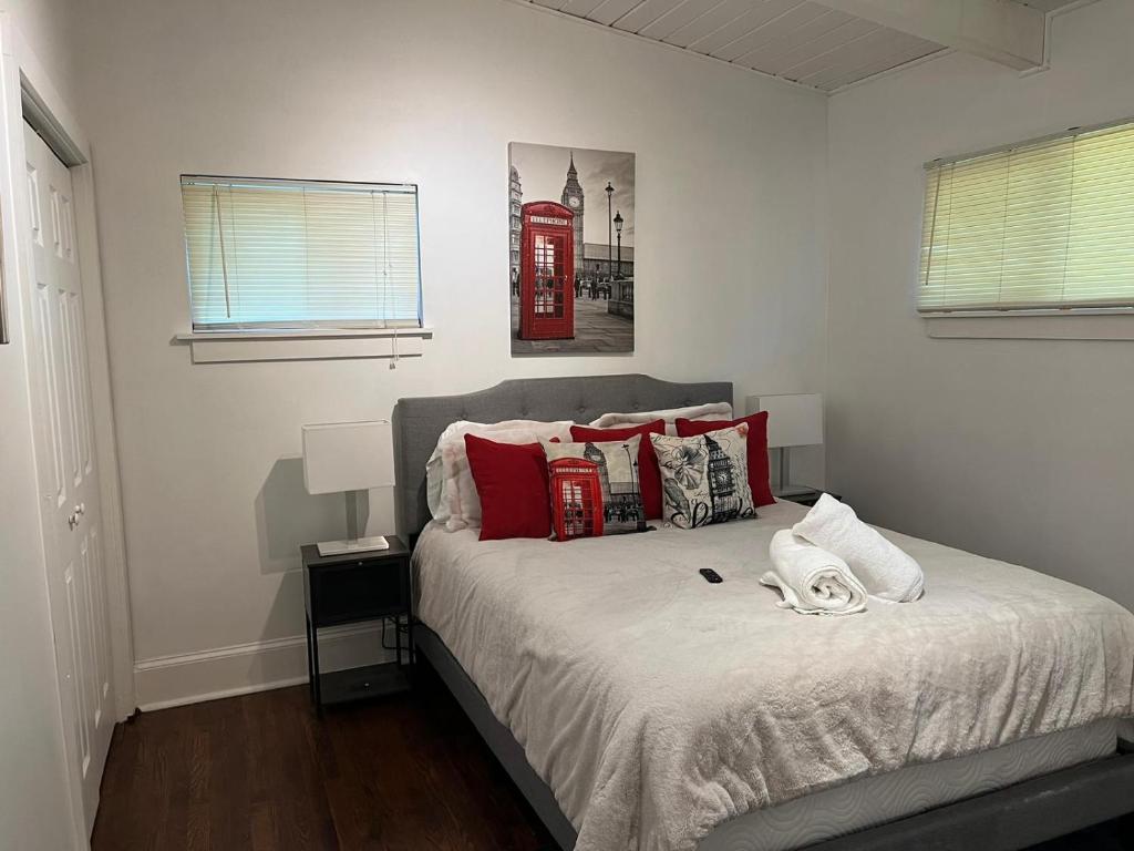 a bedroom with a bed with red pillows and a telephone booth at Recently renovated Haven in Brookhaven. in Atlanta