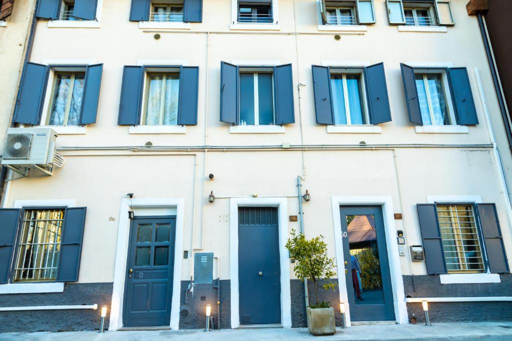 un edificio blanco con puertas y ventanas azules en Alexandra's House, en Verona