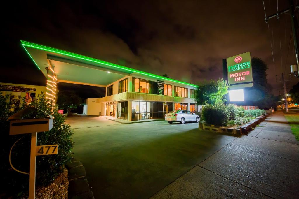 a hotel with a car parked in a parking lot at Sandown Regency Hotel & Apartments in Noble Park