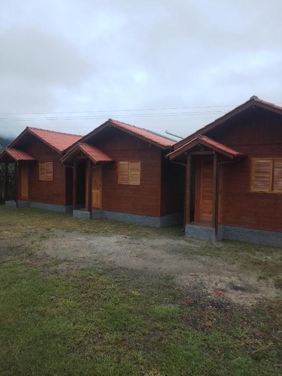 a row of wooden houses in a field at cabanas paisagem da serra in Urubici