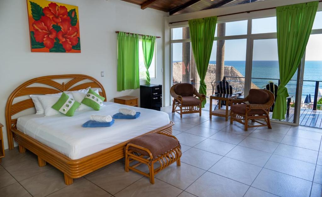 a bedroom with a bed with a view of the ocean at Kayu Surf Resort in La Libertad
