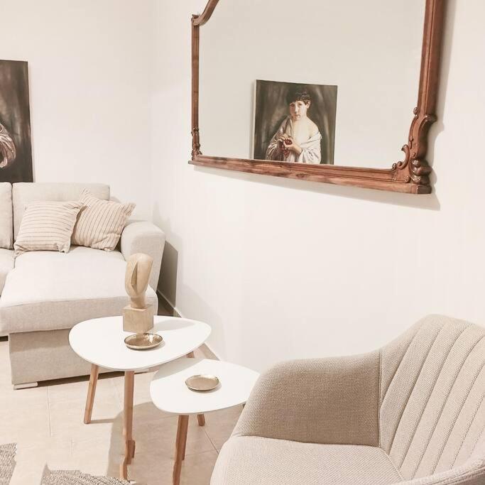 a living room with a couch and a mirror at Penthouse Pyrgos Centre Olympia in Pyrgos