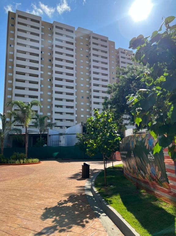 a large building with a tree in front of it at HotBeachSuites Lazer e Diversão in Olímpia