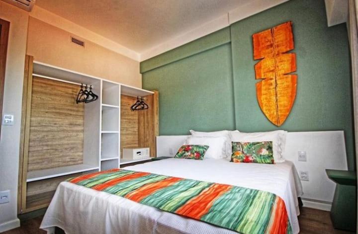 a bedroom with a bed with a surfboard on the wall at HotBeachSuites Lazer e Diversão in Olímpia