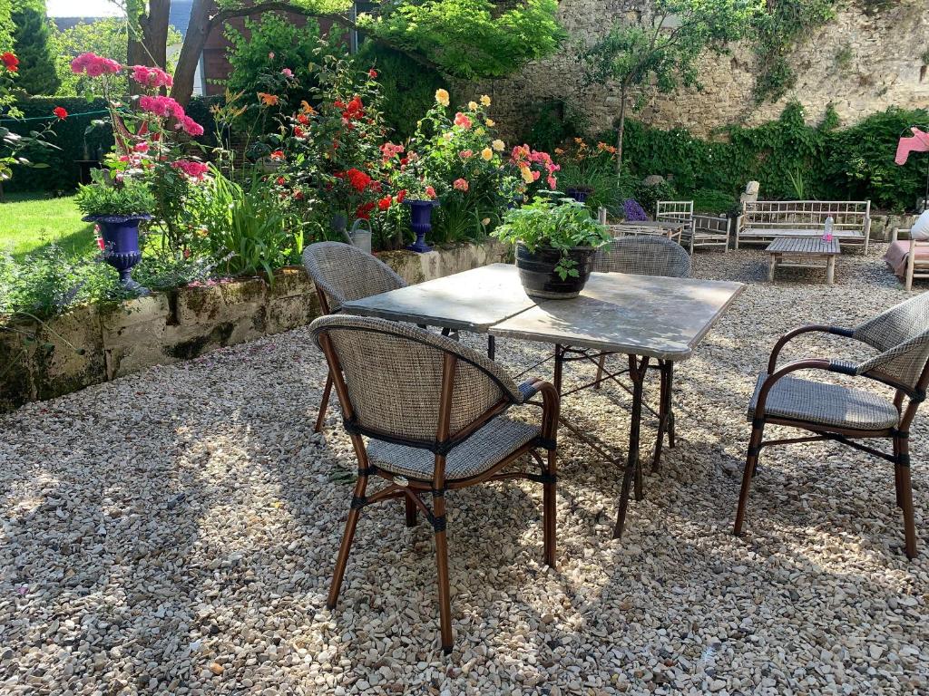 a table with two chairs and a potted plant on it at La Maison Saint Joseph in Crépy-en-Valois