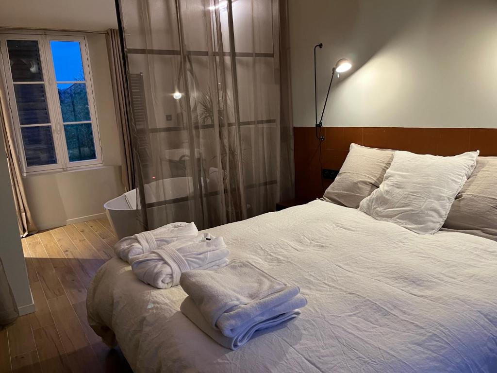 ein Schlafzimmer mit einem Bett mit Handtüchern darauf in der Unterkunft Bella Vita in Villers-Cotterêts