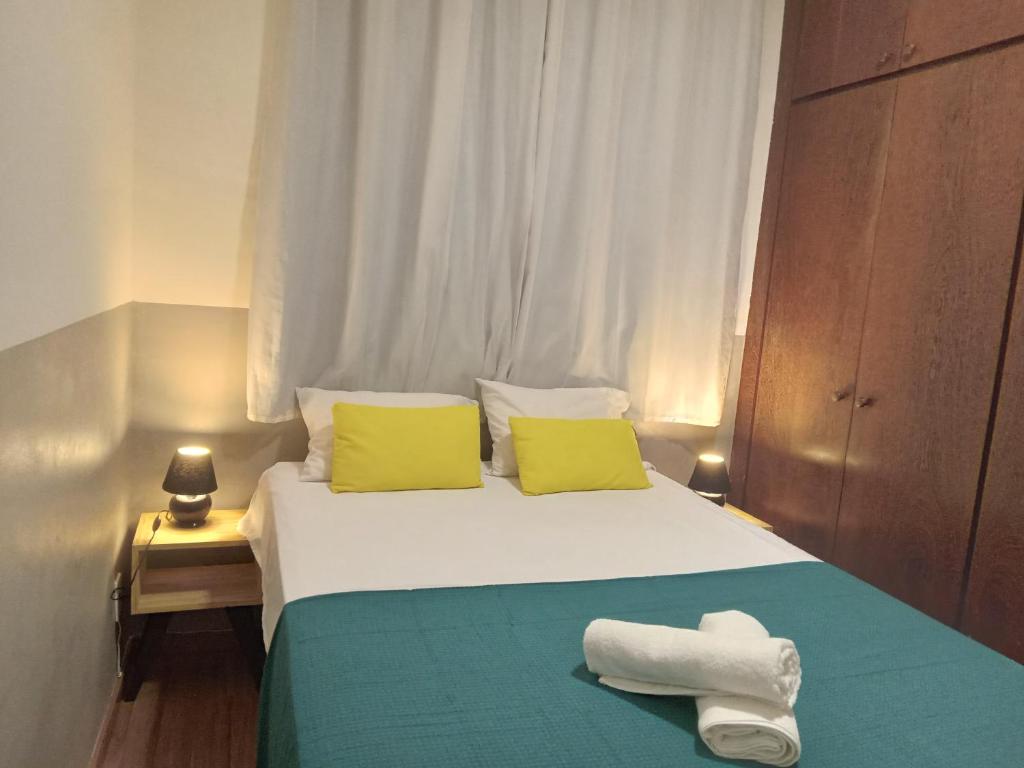 1 dormitorio con 1 cama con 2 toallas en Apartamento encantador, en Belo Horizonte