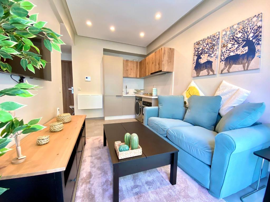 a living room with a blue couch and a table at Appartement cosy à proximité immédiate du célèbre Twins-center in Casablanca